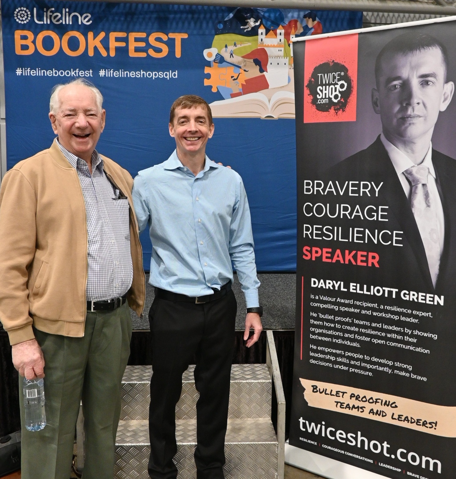 Photo Of Daryl Elliott Green And His Father Alan In Front Of A Large Lifeline Bookfest Banner At The Lifeline Brisbane Bookfest Event On Saturday 17 June 2023, Just After Daryl Spoke To Attendees.